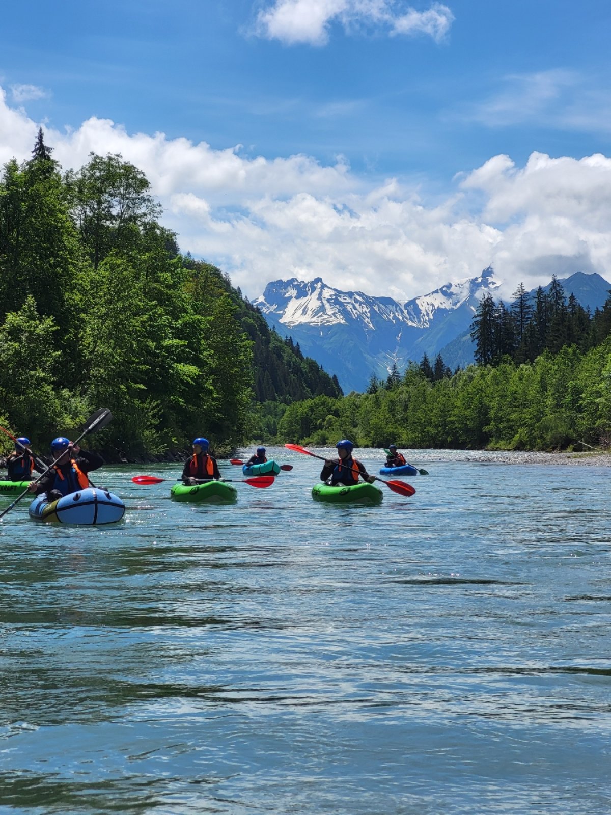 Packraft Gruppe mit Bergblick