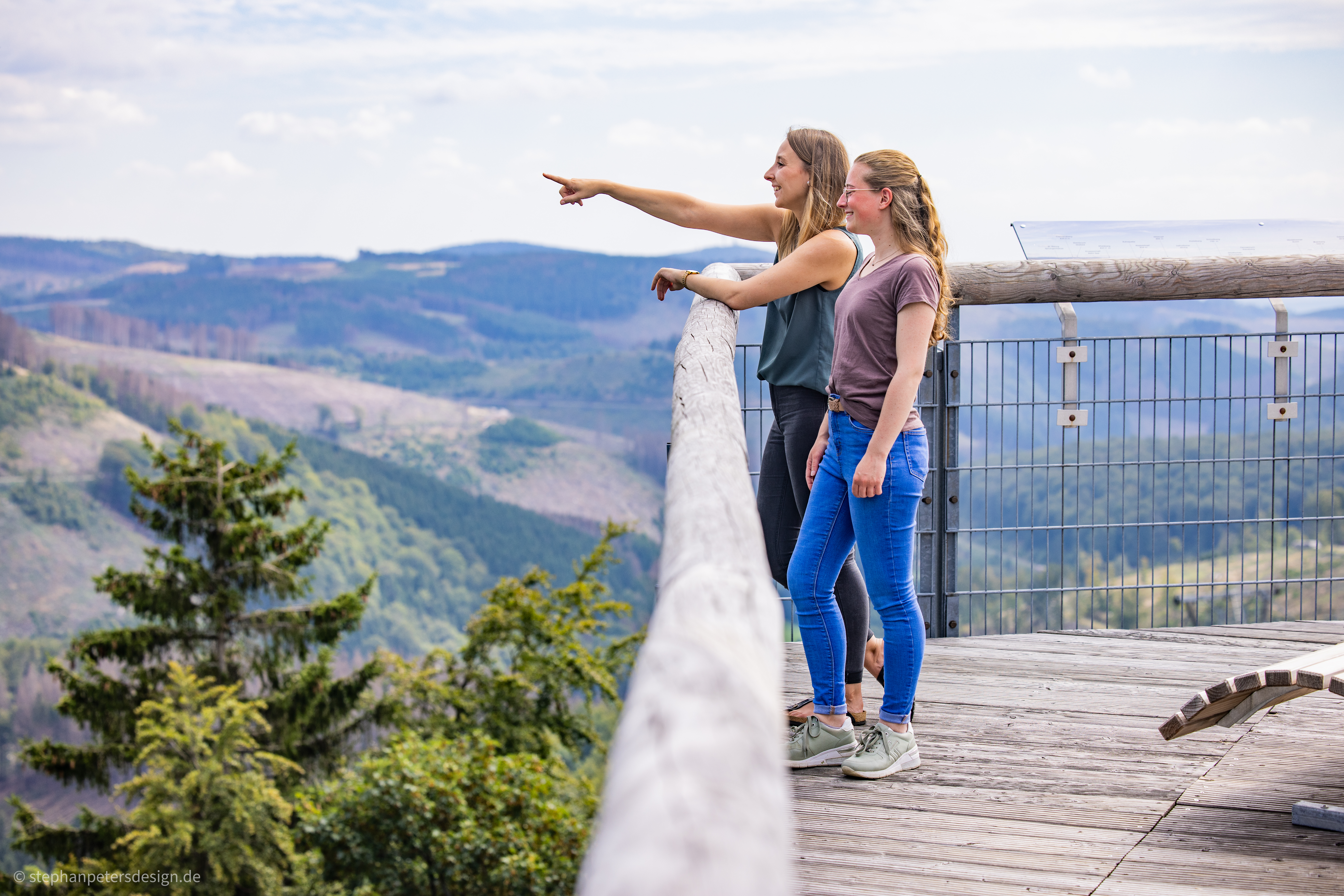 Zwei Frauen stehen auf einer hohen Brücke und blicken in die Ferne. Zwei Frauen stehen auf einer hohen Brücke und blicken in die Ferne.