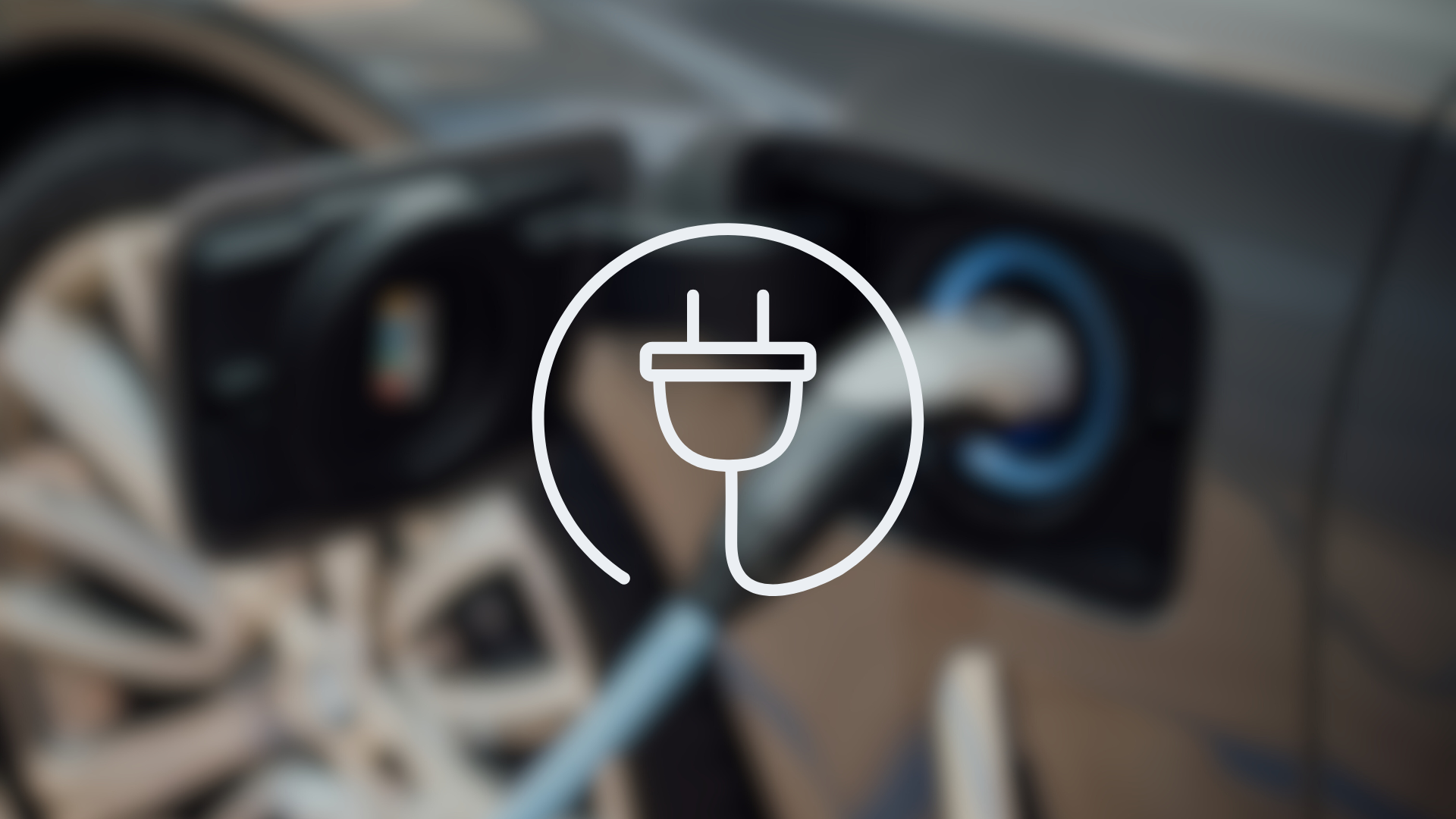 Ein verschwommenes Bild eines Ladesteckers in einer Autoladeklappe mit der Zeichnung eines Haushaltsteckers im Vordergrund. Dieses Bild dient als Symbolbild für E-Car Ladestationen.