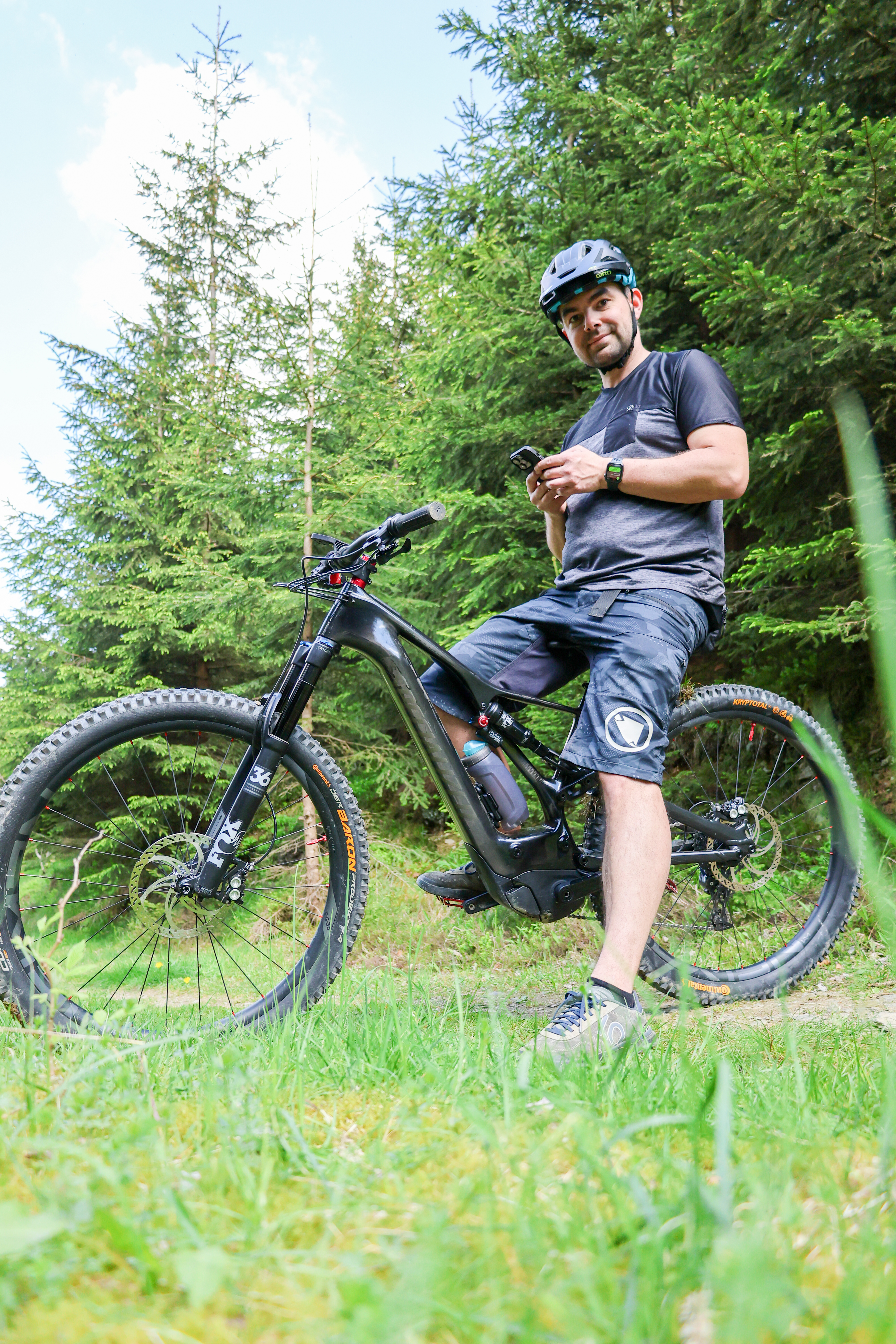 Mann auf Mountainbike der in die Kamera schaut. Drum herum grüne Natur. Mann auf Mountainbike der in die Kamera schaut. Drum herum grüne Natur.