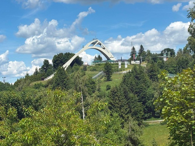Außenansicht des Restaurants Die Schanze im Sommer, umgeben von grüner Natur.